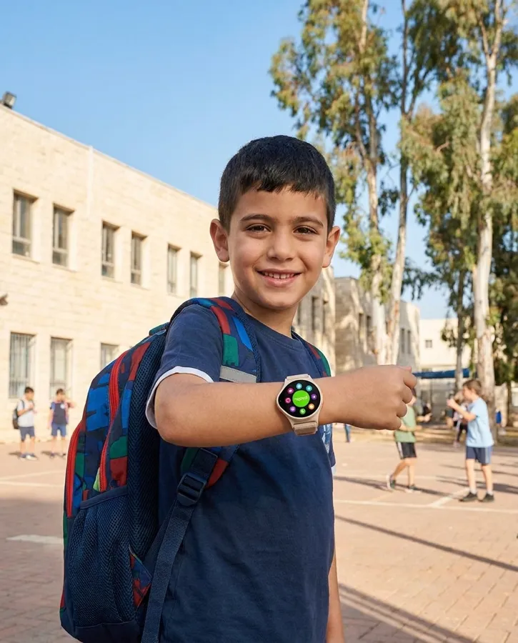 ילד בחצר בית ספר מציג את שעון NickWatch